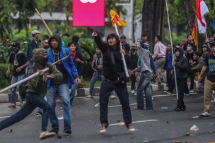 Aksi massa demo Indonesia dengan peserta memegang spanduk dan menyuarakan tuntutan mereka